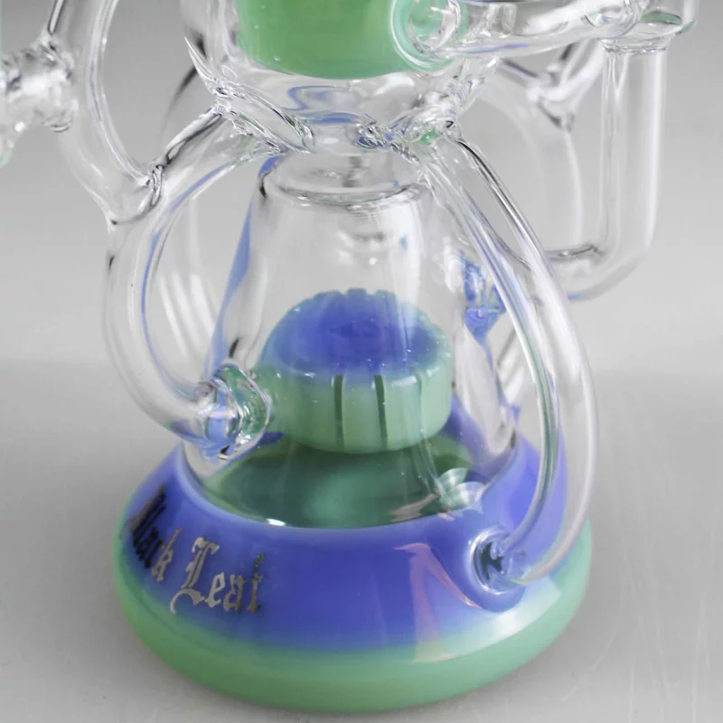 Detailsaufnahme des unteren Teils einer Recyclebong aus klarem Glas mit Akzenten in lila und grün