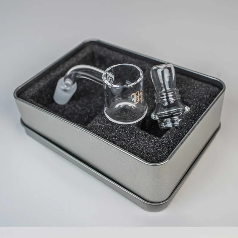 kleine silberne Metallbox mit schwarzem Schaumstoff ausgelegt, darin Banger und Carb Cap aus Glas