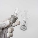 Glaskopf mit grauem Gummidichtungsring in einer Hand mit Handschuh gehalten, unscharfe Bong im Hintergrund