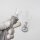 Glaskopf mit grauem Gummidichtungsring in einer Hand mit Handschuh gehalten, unscharfe Bong im Hintergrund