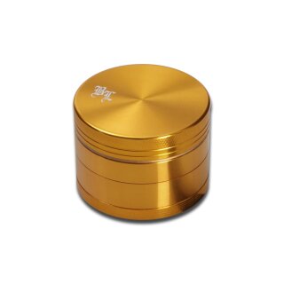 Grinder, zylindrisch, aus goldfarbenem Metall mit geriffeltem Rand, sichtbarem vierteiligen Aufbau und graviertem Logo auf der Oberseite links. Glänzende Oberfläche.