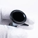  Glas-Pfeife in Schwarz, gehalten von einer Hand in weißen Handschuhen. Klares, glattes Glas mit runder Öffnung und kurzem Hals. Keine sichtbaren Verzierungen oder Logos.