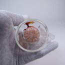 Alt-Text: Glasbong-Mundstück aus klarem Material mit mehrfarbigem, gesprenkeltem Perkolator, gehalten von einer Hand in grauem Handschuh.