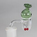 Alt-Text: Glas-Dab-Rig-Zubehör mit grünem Glaskuppelaufsatz und zwei roten Kügelchen im klaren Glasgefäß. Seitlicher Glasarm verbunden mit weißem Stecksystem.