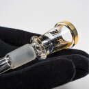 Schwarzer Handschuh präsentiert liegend Glas-Chillum: Goldener Rand, transparentes Glas mit schwarzem Schriftzug, matter Schliff.